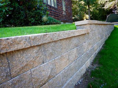 Modular block stone wall on side of house.