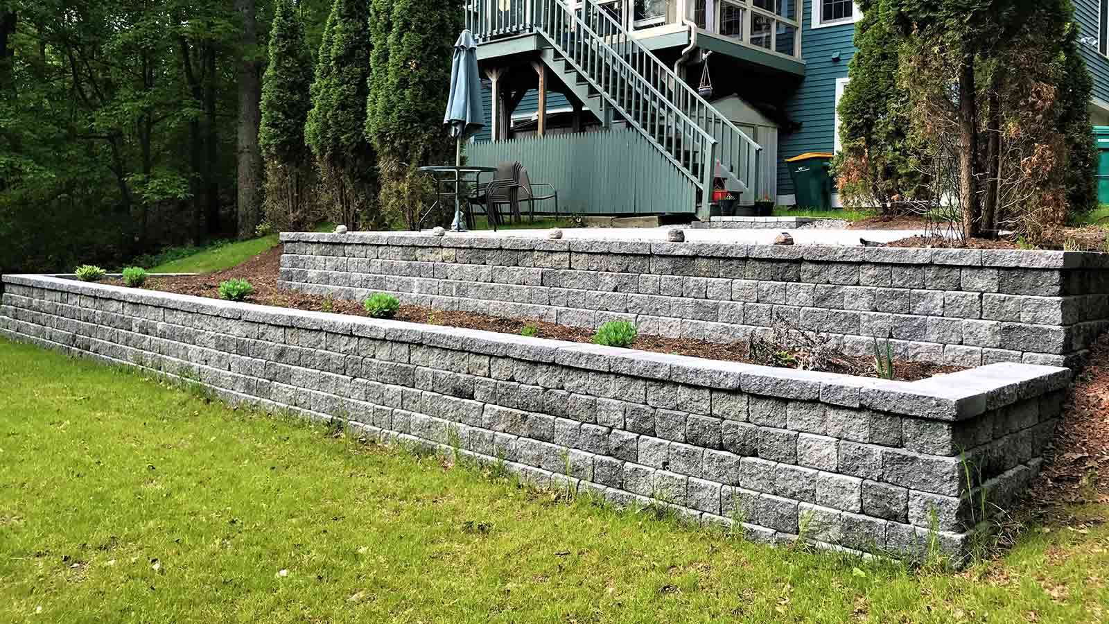 back yard modular block retaining wall with planting beds