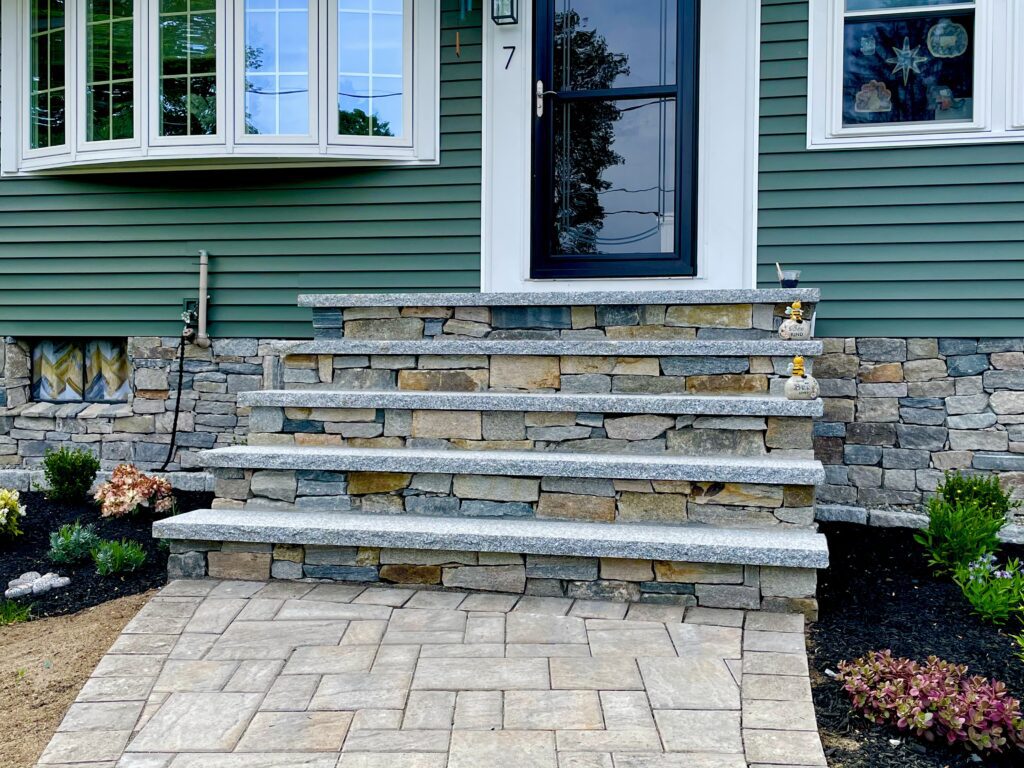 front entryway custom veneer stone steps with granite treads and paver walkway