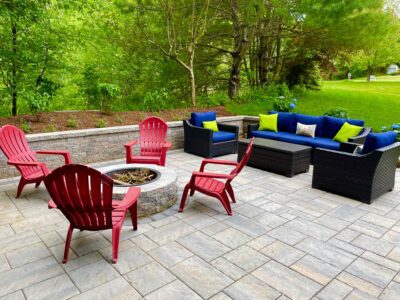 outdoor paver patio with circular fire pit and sitting wall