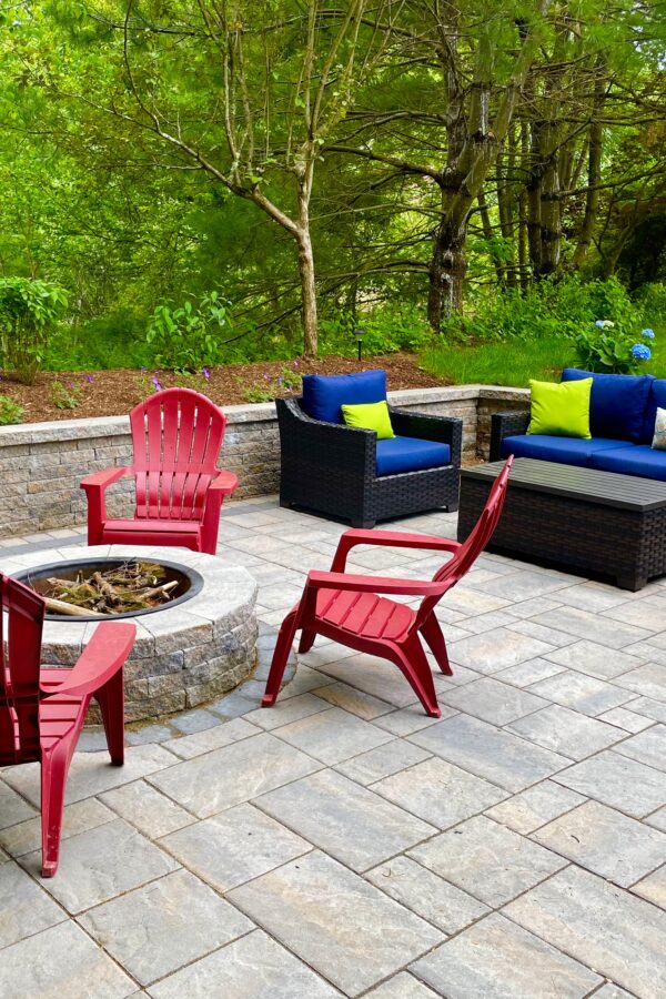outdoor paver patio with circular fire pit and sitting wall