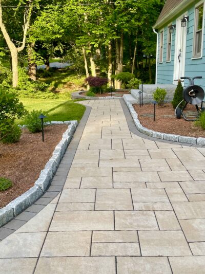front yard walkway with cobblestone border and granite steps