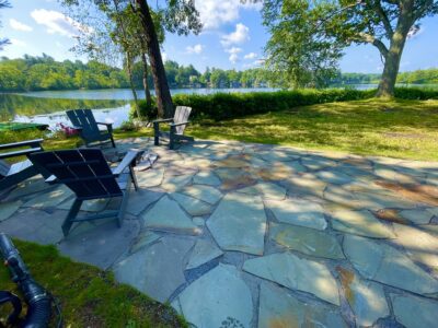 back yard stone patio with fire pit and Adirondack chairs