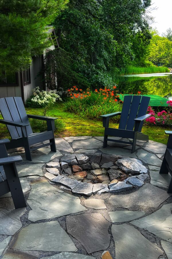 back yard stone patio with natural fire pit