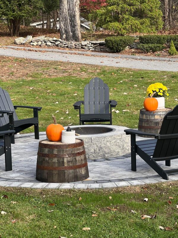 backyard paver patio with fire pit and adirondack chairs