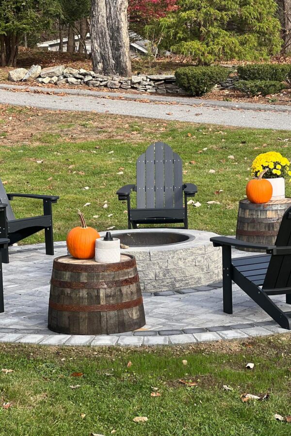 backyard paver patio with fire pit and adirondack chairs