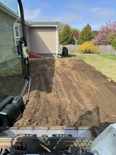 before picture of back yard paver patio with black onyx border