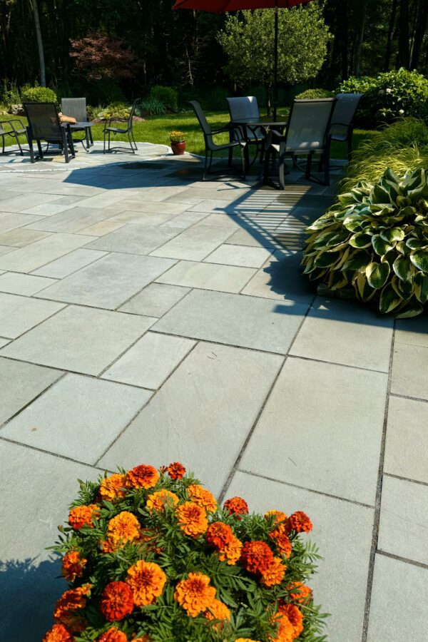 outdoor bluestone patio with fire pit and lawn furniture