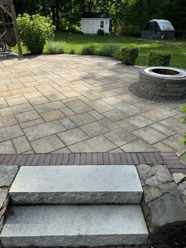 back yard paver patio with granite steps and fire pit