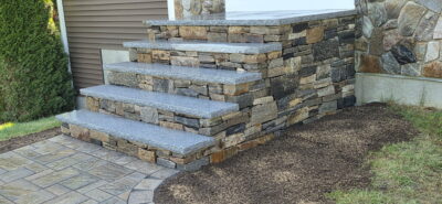 - Courtyard Concepts front walkway with veneer stone steps and granite treads